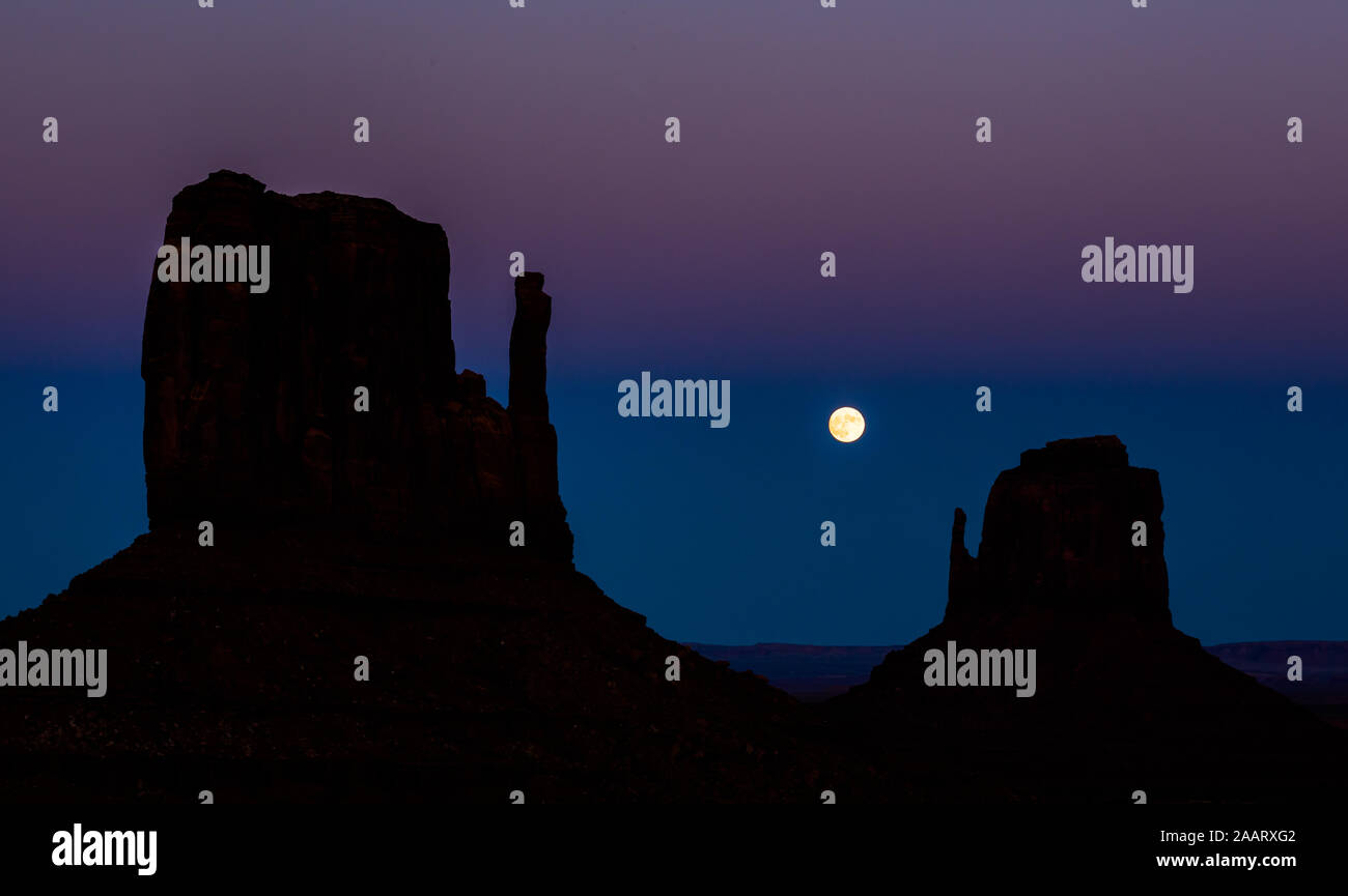 Full moon rising between silhouettes of the iconic mitten formations of ...
