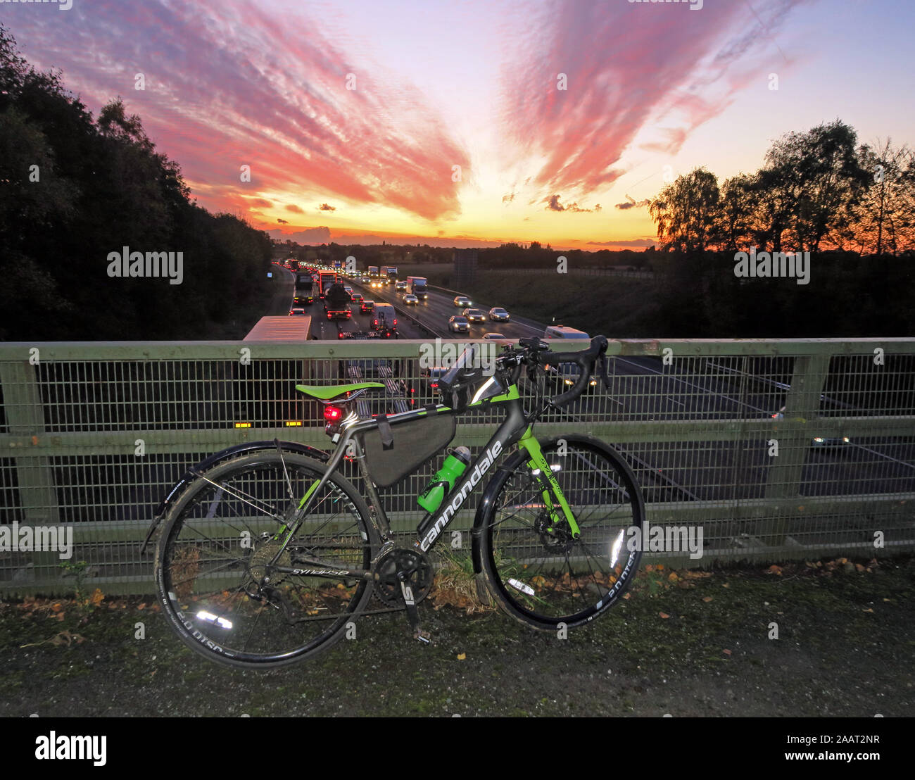 Cycle parked overlooking a busy road, with sunset, Warrington, Cheshire, UK - enjoy cycling Stock Photo
