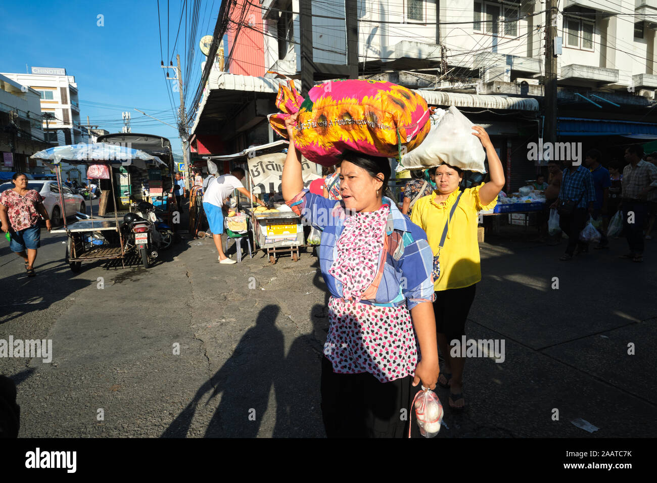 Female migrant workers from Myanmar (Burma) carrying goods on their heads, after Sunday shopping in the main market in Phuket Town, Phuket, Thailand Stock Photo
