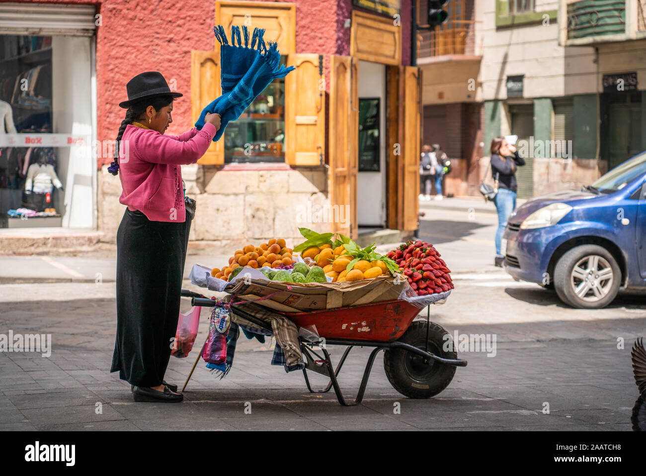 Indigenous (Native American) woman selling mangoes, strawberries, and