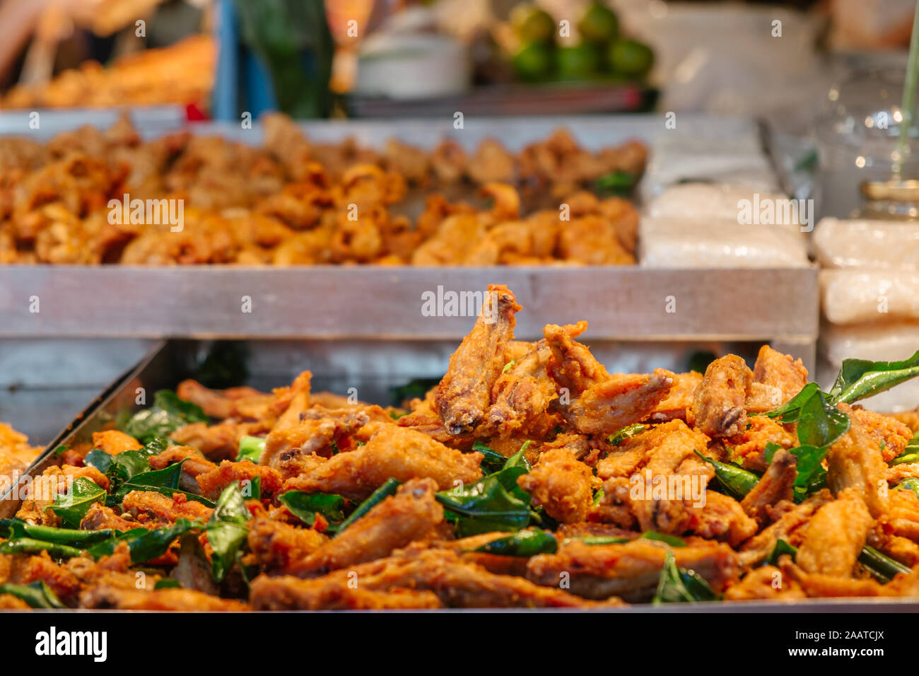 Heap of Thai style deep fried crispy chicken wings for sale in the local street food market in Bangkok, Thailand. Stock Photo