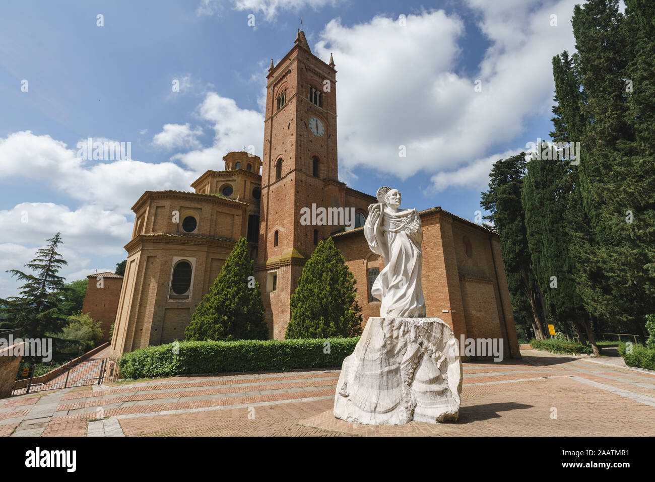 Ancient Church on the Mountain in Tuscany, Abbazia di Monte Oliveto Maggiore with Statue and Road Stock Photo