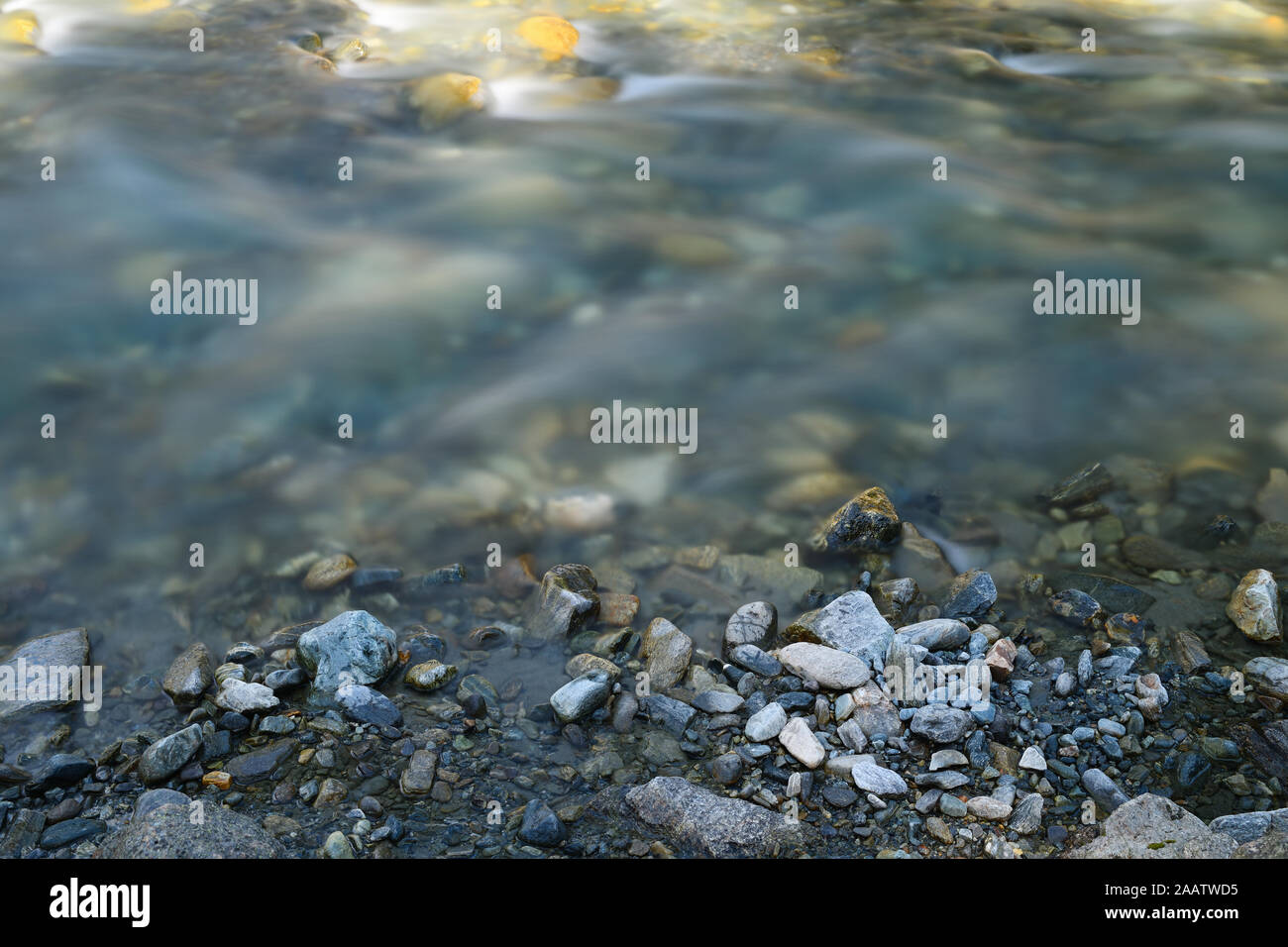 Alpine mountain river with beautiful natural rocks and pebbles. Long exposure photography, capturing motion. Stock Photo