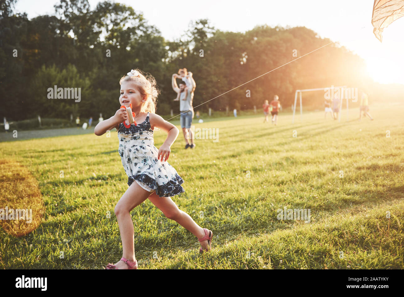 Cute Little Girl With Long Hair Running With Kite In The Field On