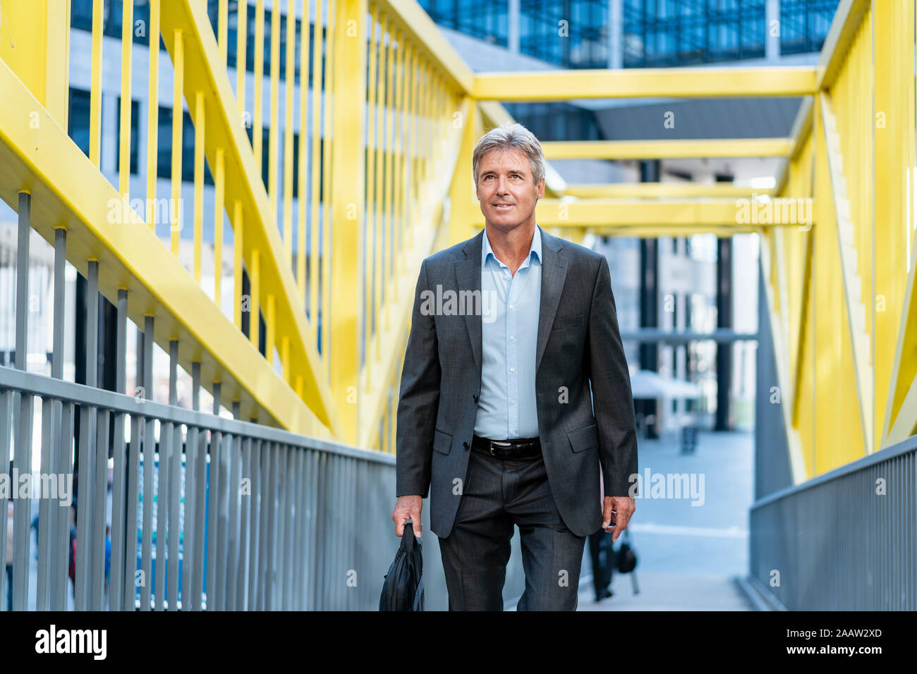 Mature businessman walking on a bridge Stock Photo