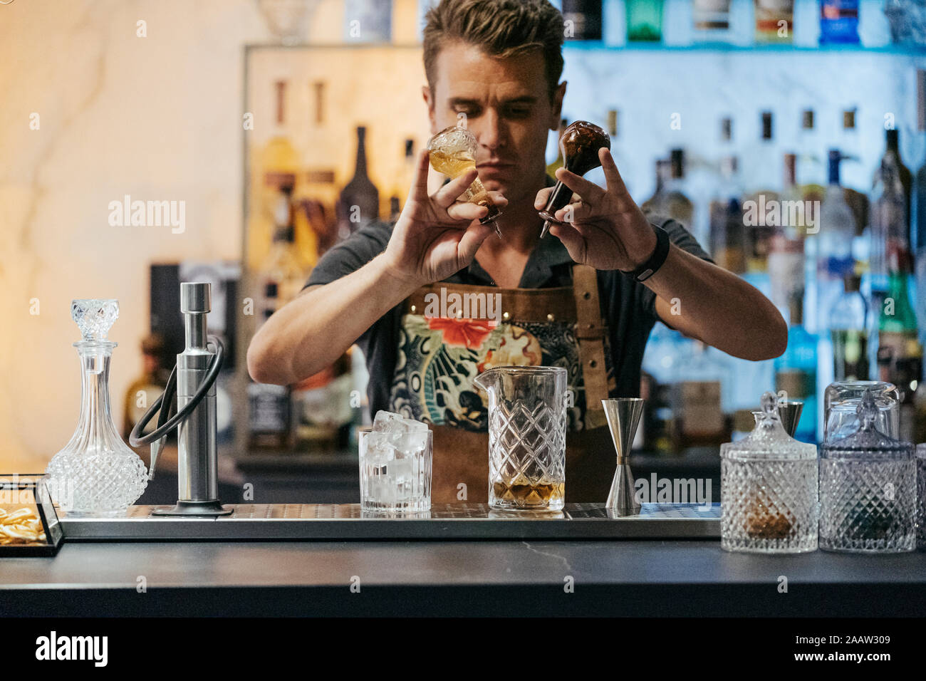 Bartender mixing cocktail in a bar Stock Photo