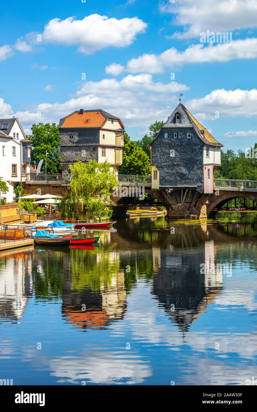 Bridge houses over boats moored on river in Bad Kreuznach, Germany Stock Photo