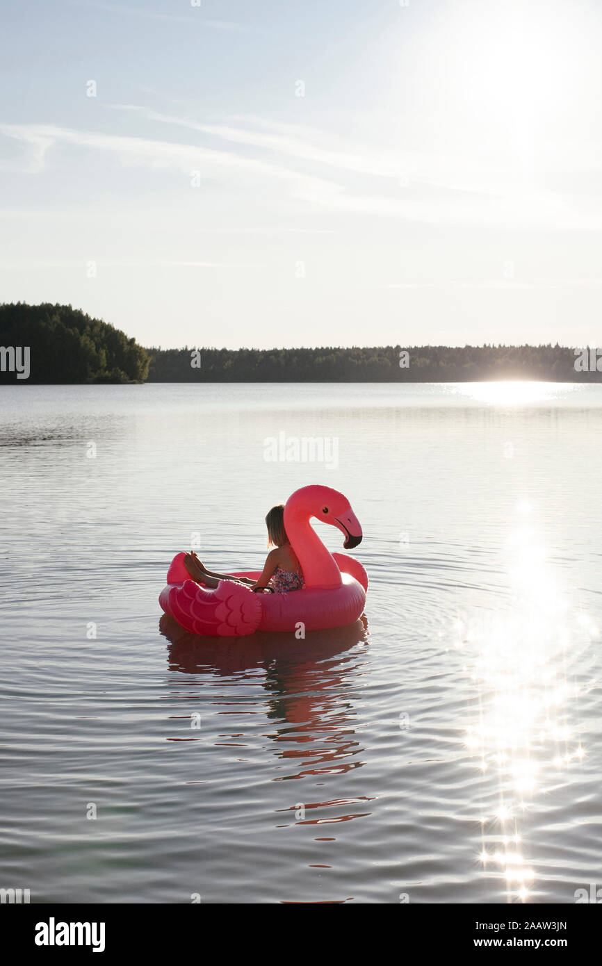 Girl with flamingo pool float on a lake Stock Photo