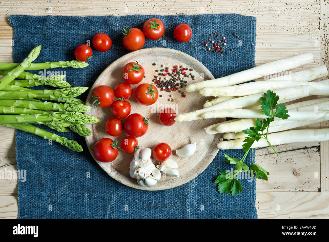 Directly above shot of asparagus with tomatoes and spices on wooden table Stock Photo