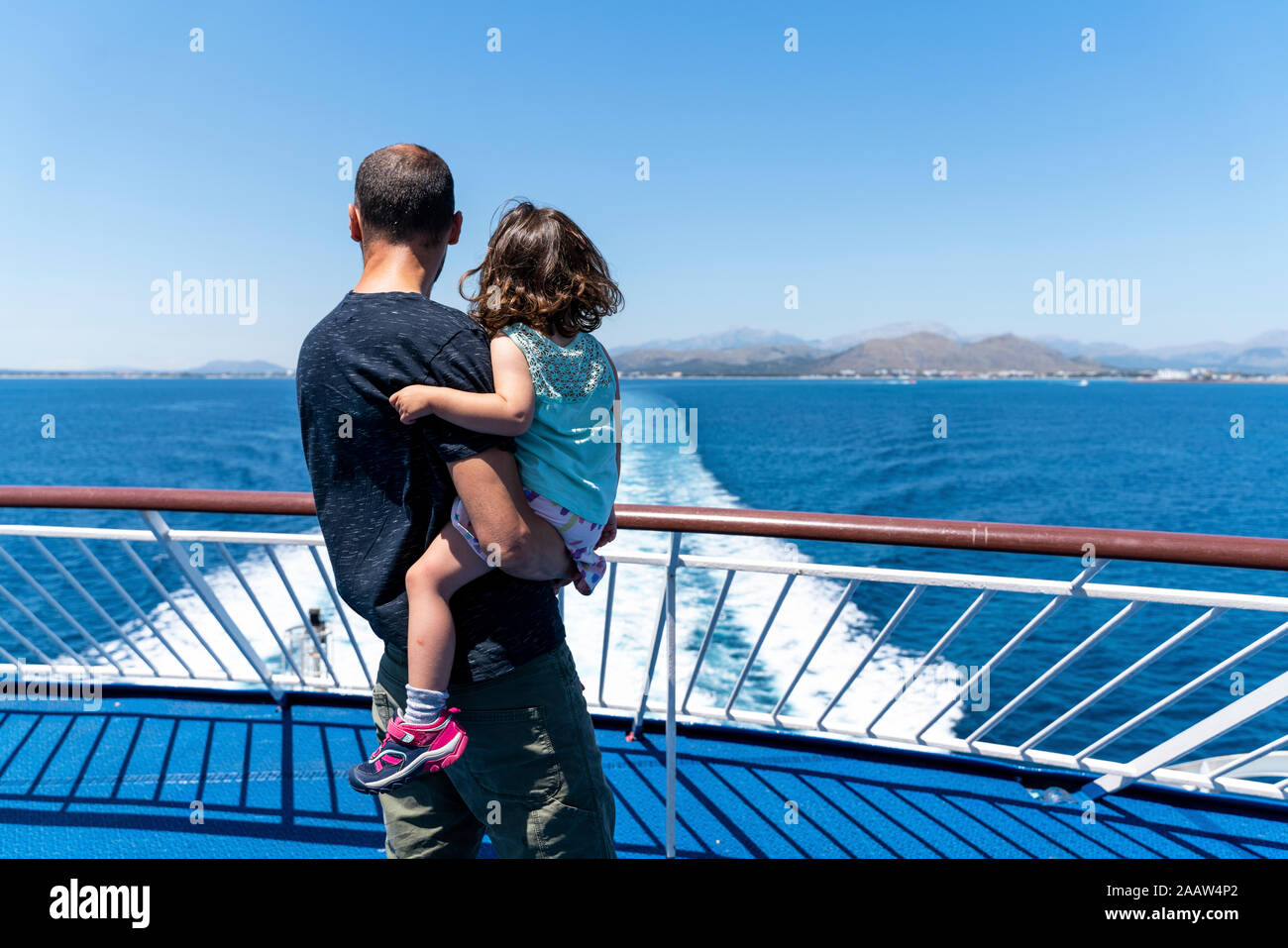 Back view of father and little daughter together on the deck of a ship looking at distance, Mallorca, Spain Stock Photo