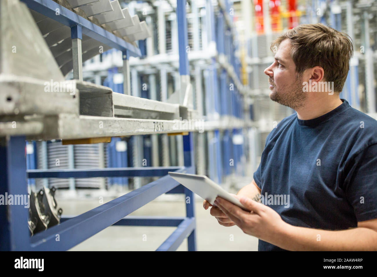 Worker using tablet in factory warehouse Stock Photo