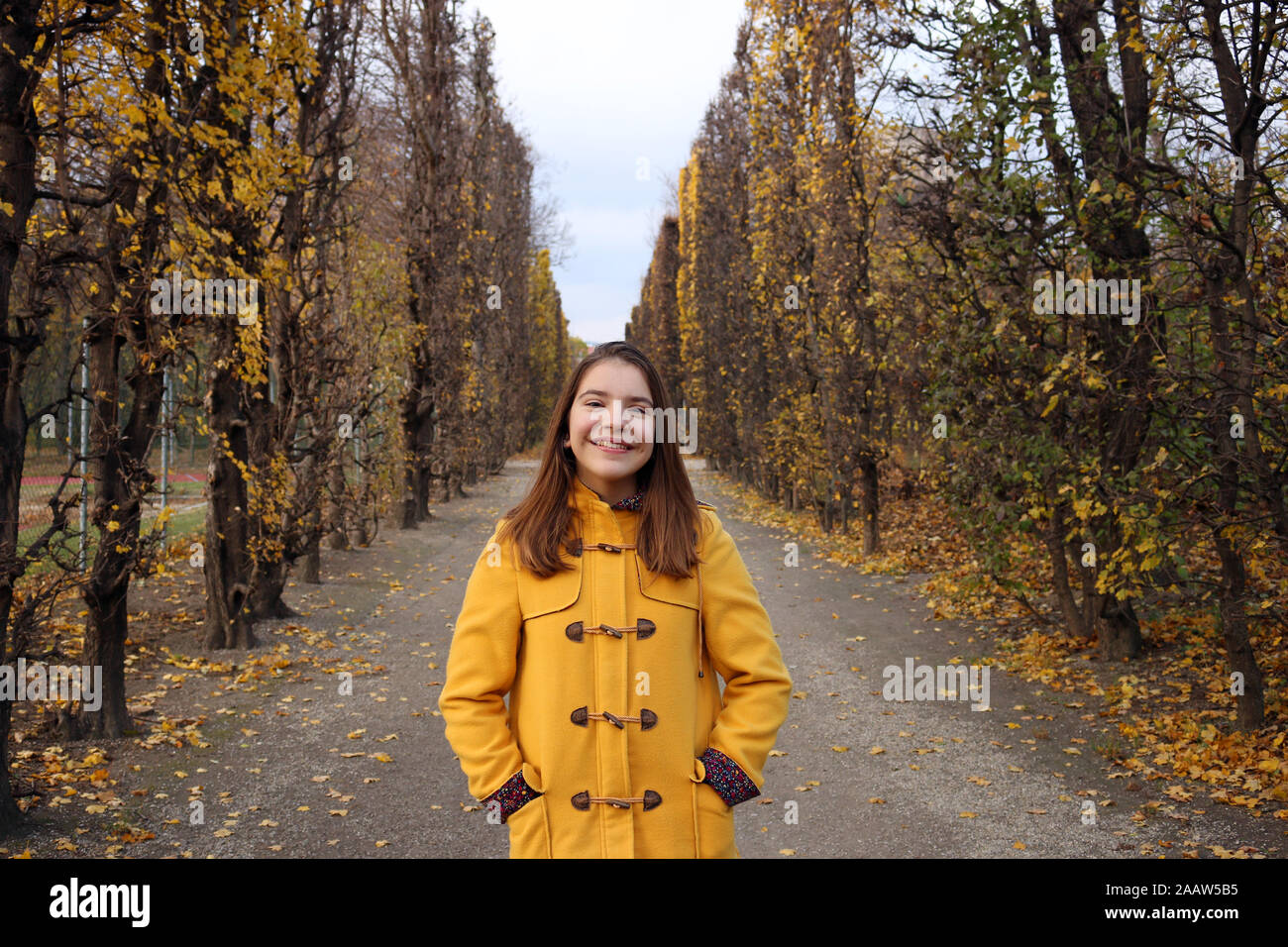 happy girl in a yellow coat portrait Augarten Vienna Stock Photo - Alamy