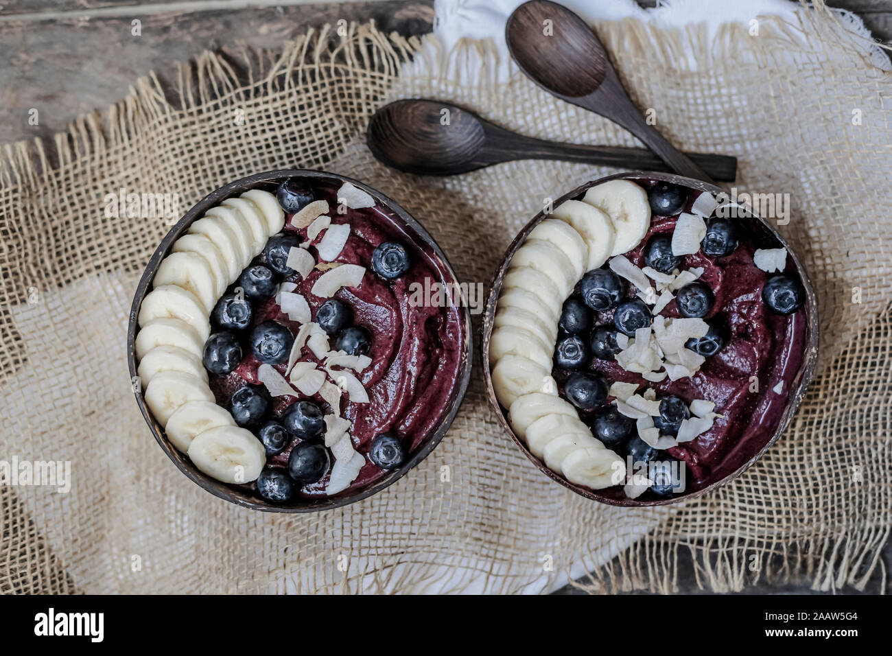 Directly above shot of ice cream served with banana slices and blueberries in bowls on table Stock Photo