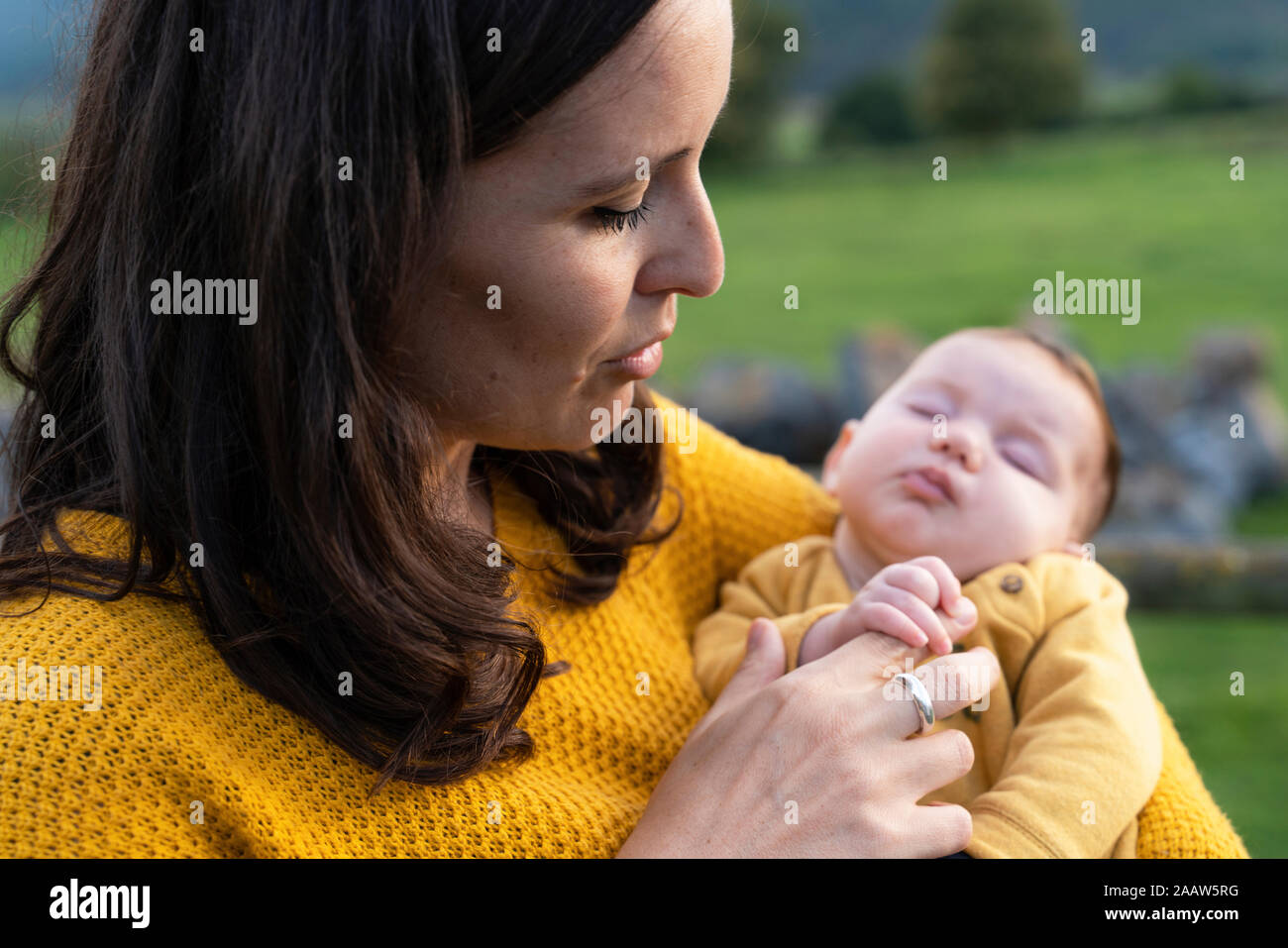 Mother holding sleeping baby girl in her arms Stock Photo