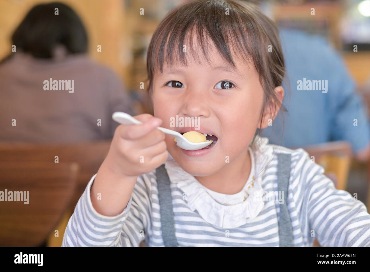 Little asian child girl having lunch on table in restaurant Stock Photo