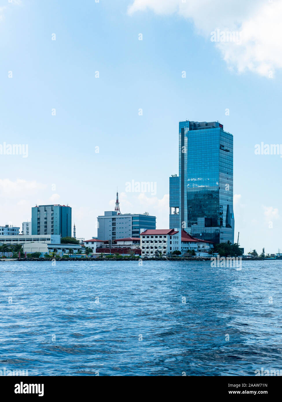 Buildings by North Malé Atoll against blue sky at Maldives Stock Photo