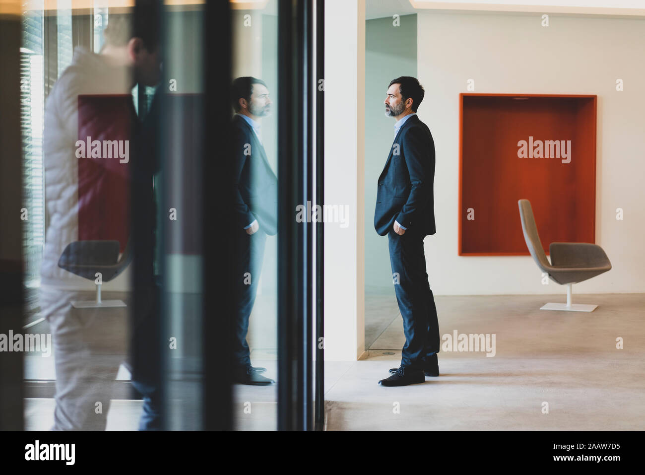 Mature businessman standing at the window in office Stock Photo
