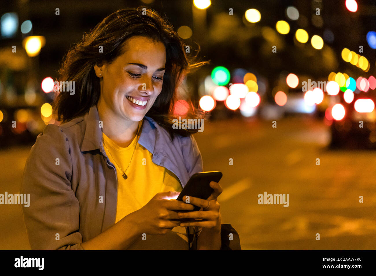 Young woman using smartphone in the city at night Stock Photo