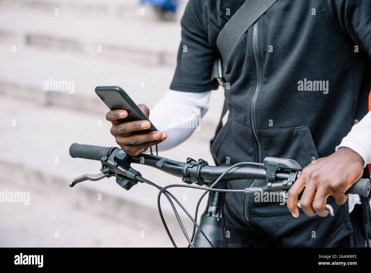 Close-upof man with bicycle using smartphone Stock Photo
