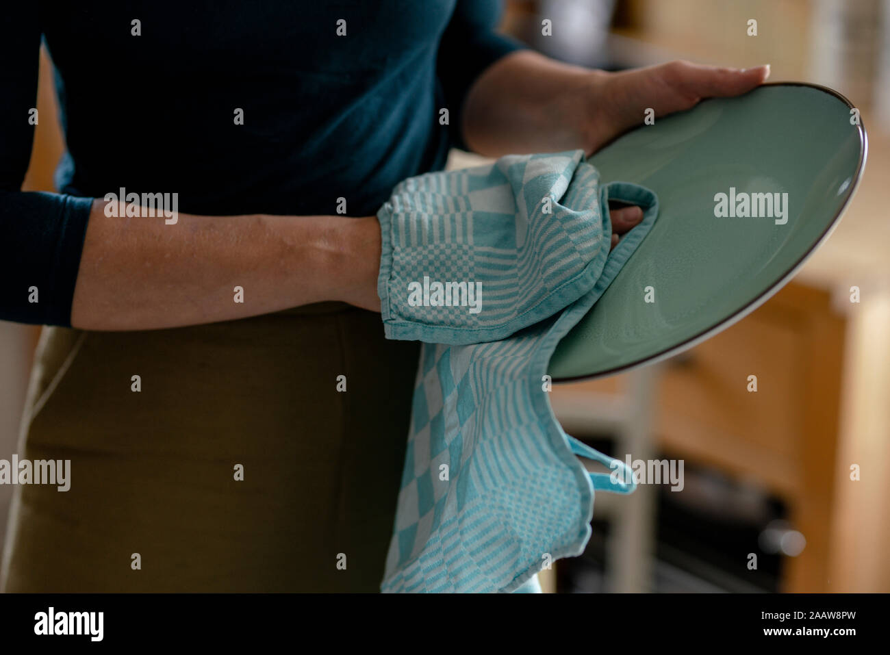 Woman drying plate with dish towel, close-up Stock Photo