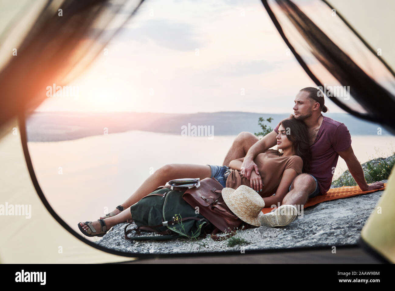 View from tent of couple lying a view of lake during hiking trip. avel Lifestyle concept adventure vacations outdoor Stock Photo