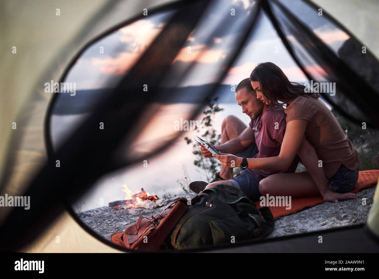 View from tent of couple with map lying a view of lake during hiking trip. avel Lifestyle concept adventure vacations outdoor Stock Photo