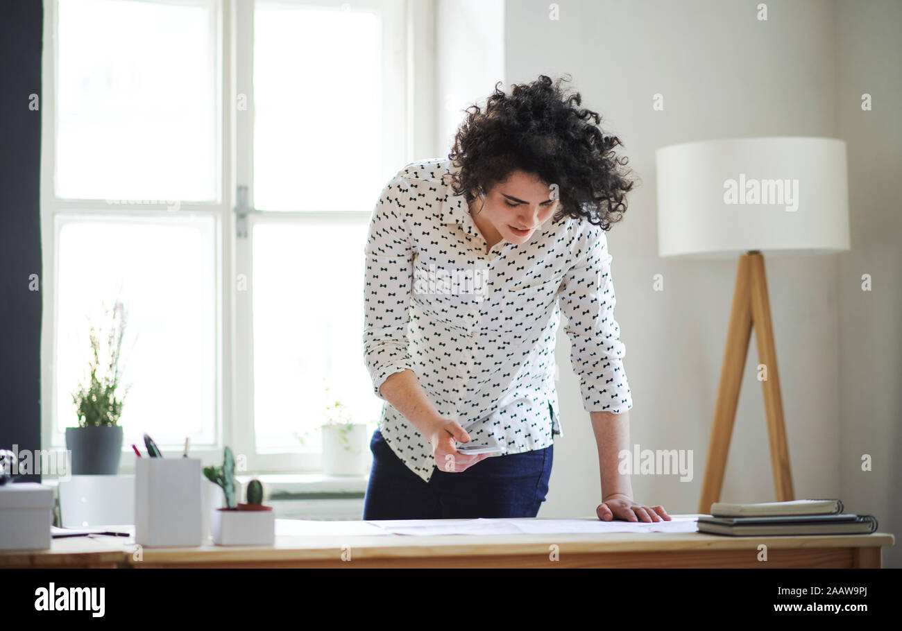 Young woman leaning over desk hi-res stock photography and images - Alamy