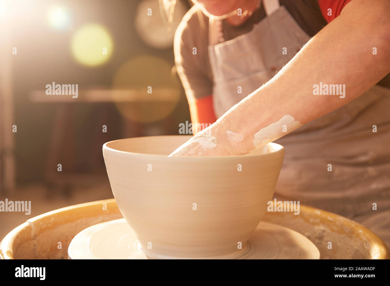 Female potter in her workshop at a shelf Stock Photo