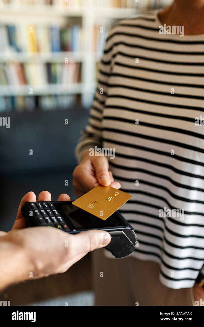 Close-up of woman paying with credit card at home Stock Photo