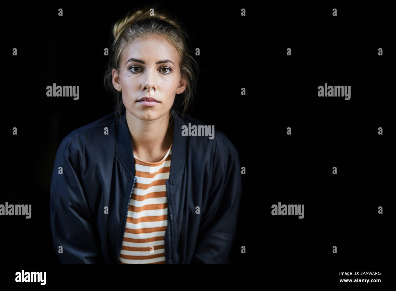 Portrait of a young woman in front of a black background Stock Photo