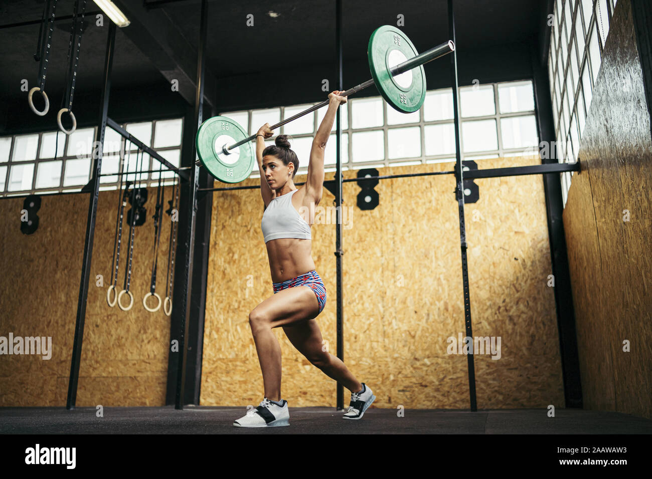 Young woman doing overhead squat exercise at gym Stock Photo - Alamy
