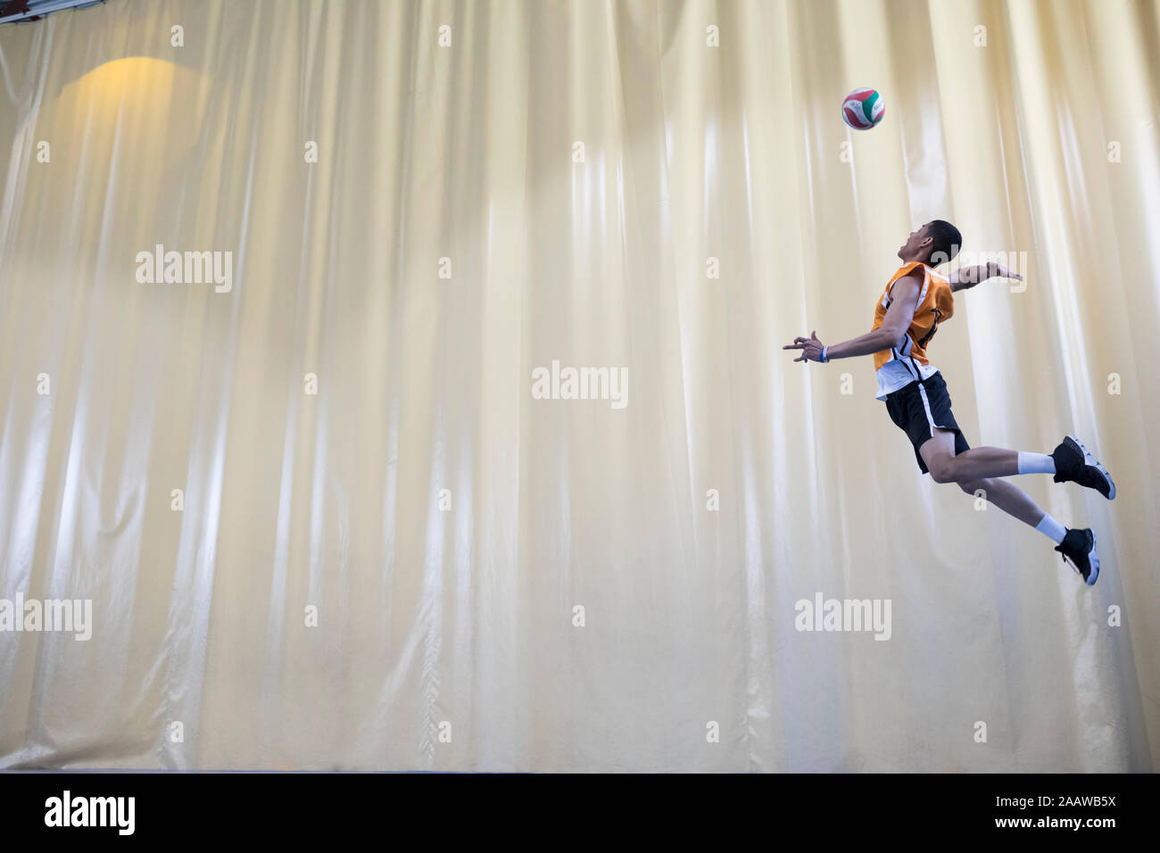 Man jumping during a volleyball match to start a game Stock Photo