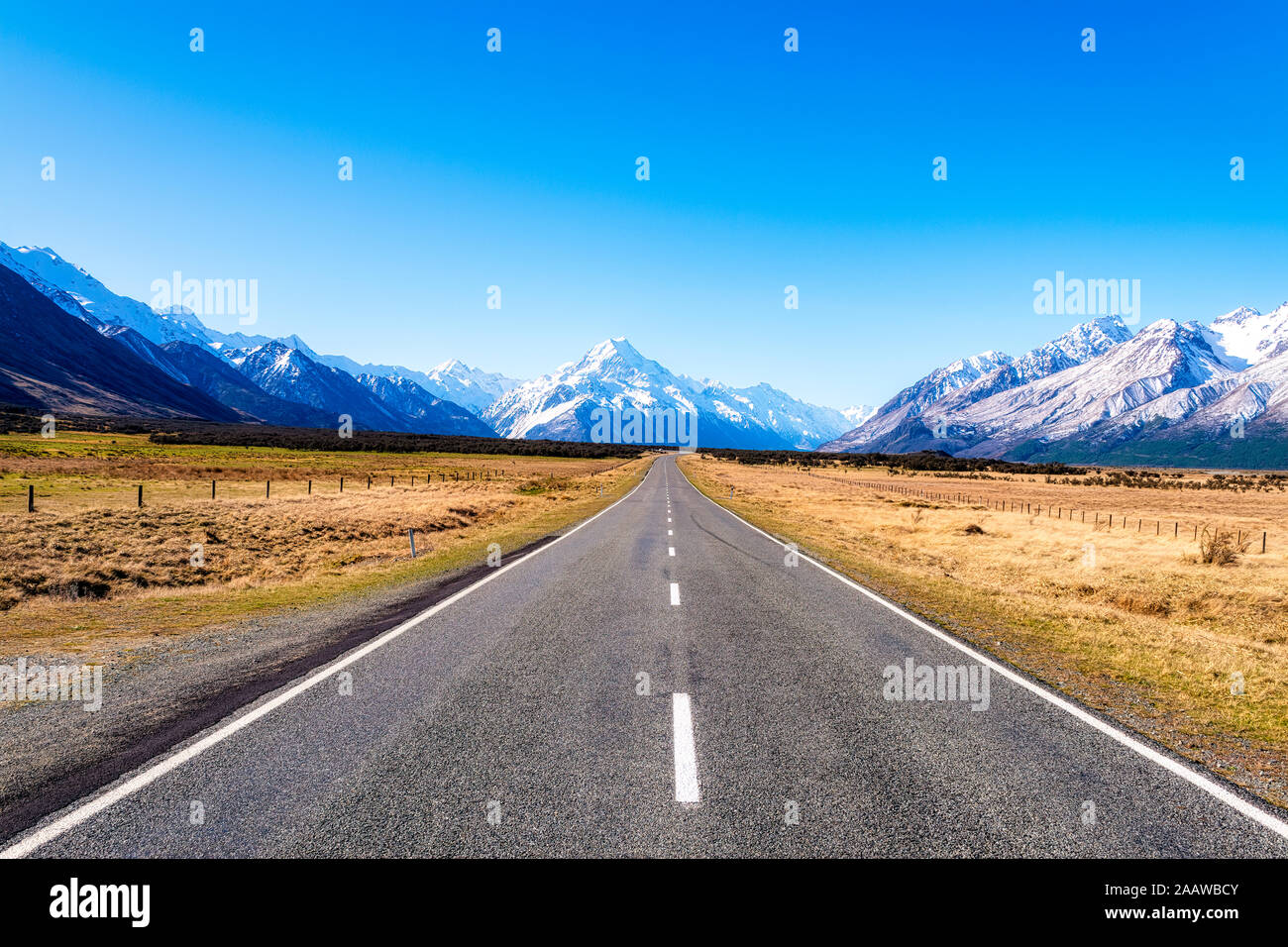 New Zealand, South Island, Diminishing perspective of Starlight Highway towards snowcapped mountains Stock Photo