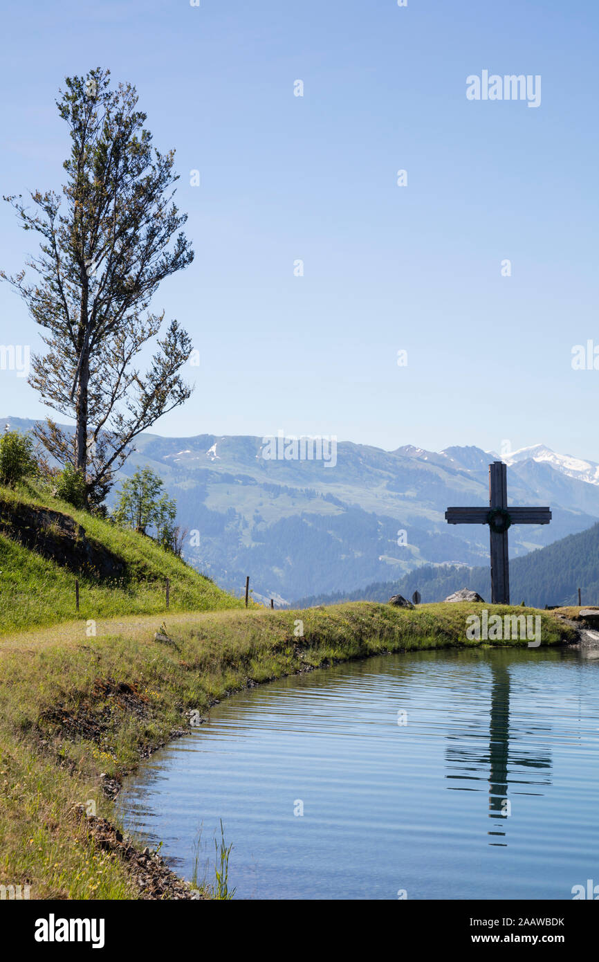 Cross by Astbergsee lake against clear sky at Astberg, Kitzbühel, Tyrol, Austria Stock Photo