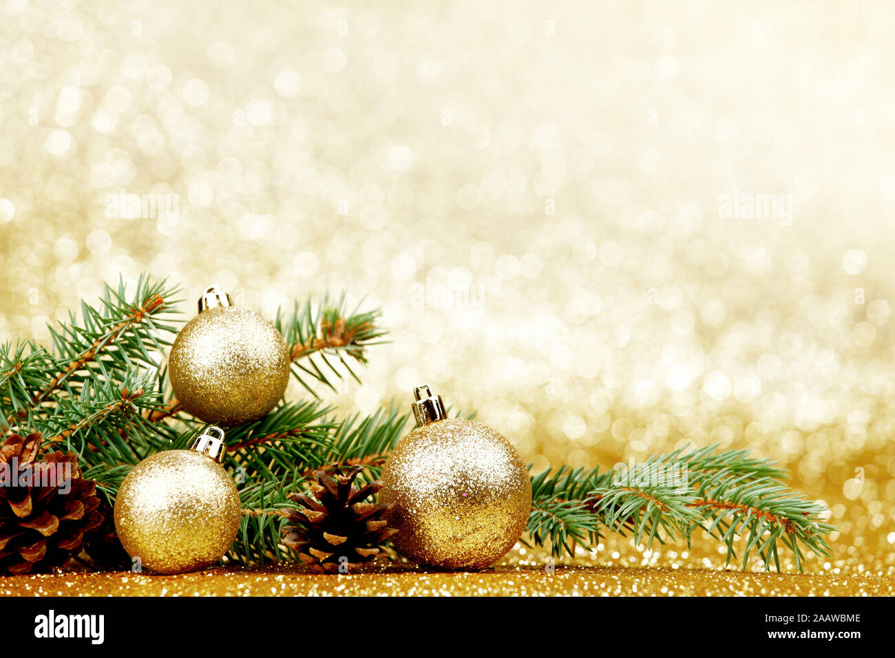Christmas card with fir tree branch and decoration on golden glitter ...