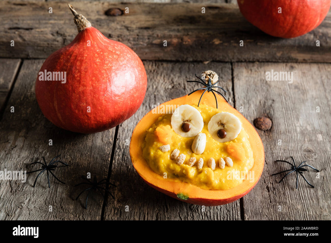High angle view of pumpkin with anthropomorphic face on wooden table during Halloween Stock Photo