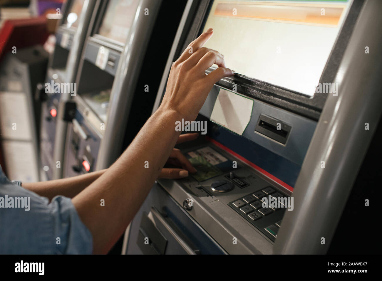 Young female traveller buying ticket from automated machine at station Stock Photo