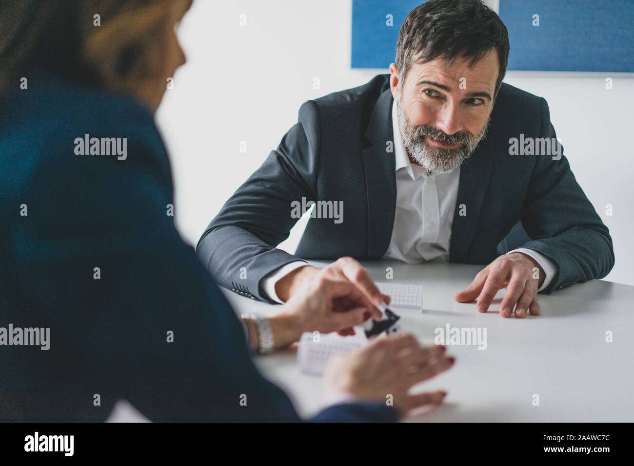 Businessman and businesswoman playing table football in office Stock Photo