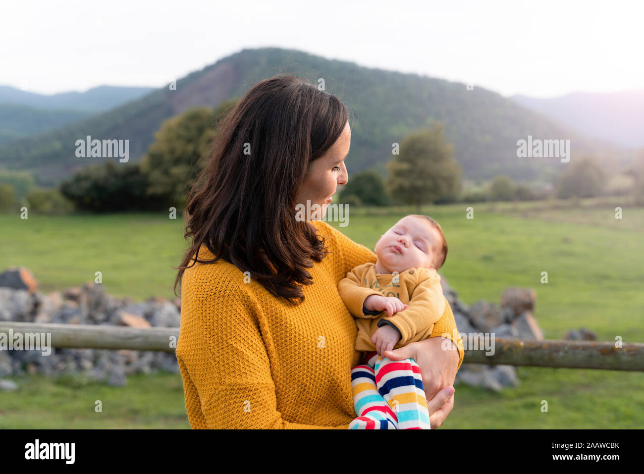 Mother holding sleeping baby girl in her arms, Olot, Spain Stock Photo