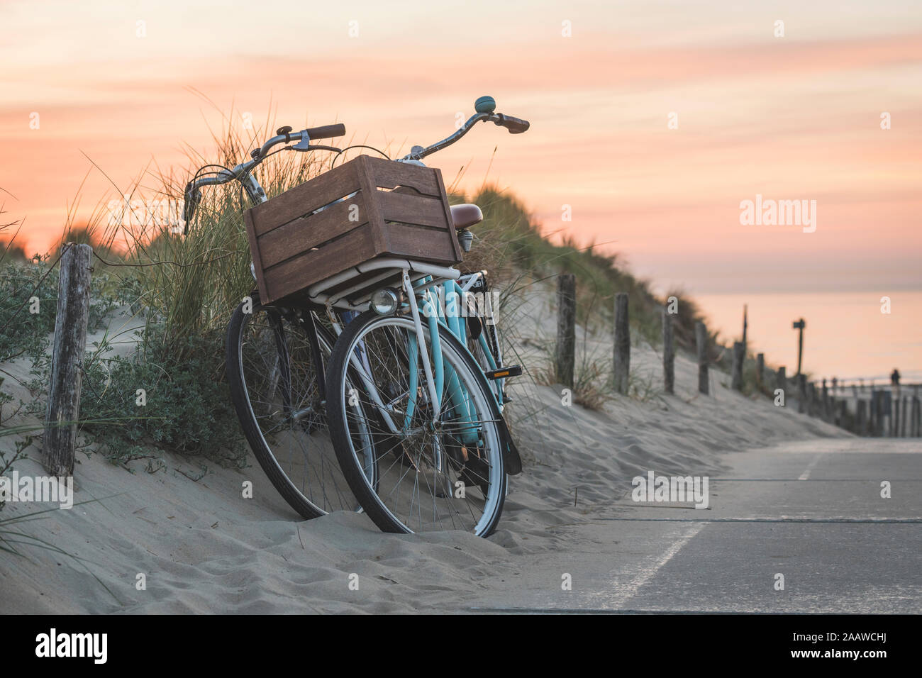 Netherlands, South Holland, Noordwijk, bicycles on sandy beach at sunset Stock Photo