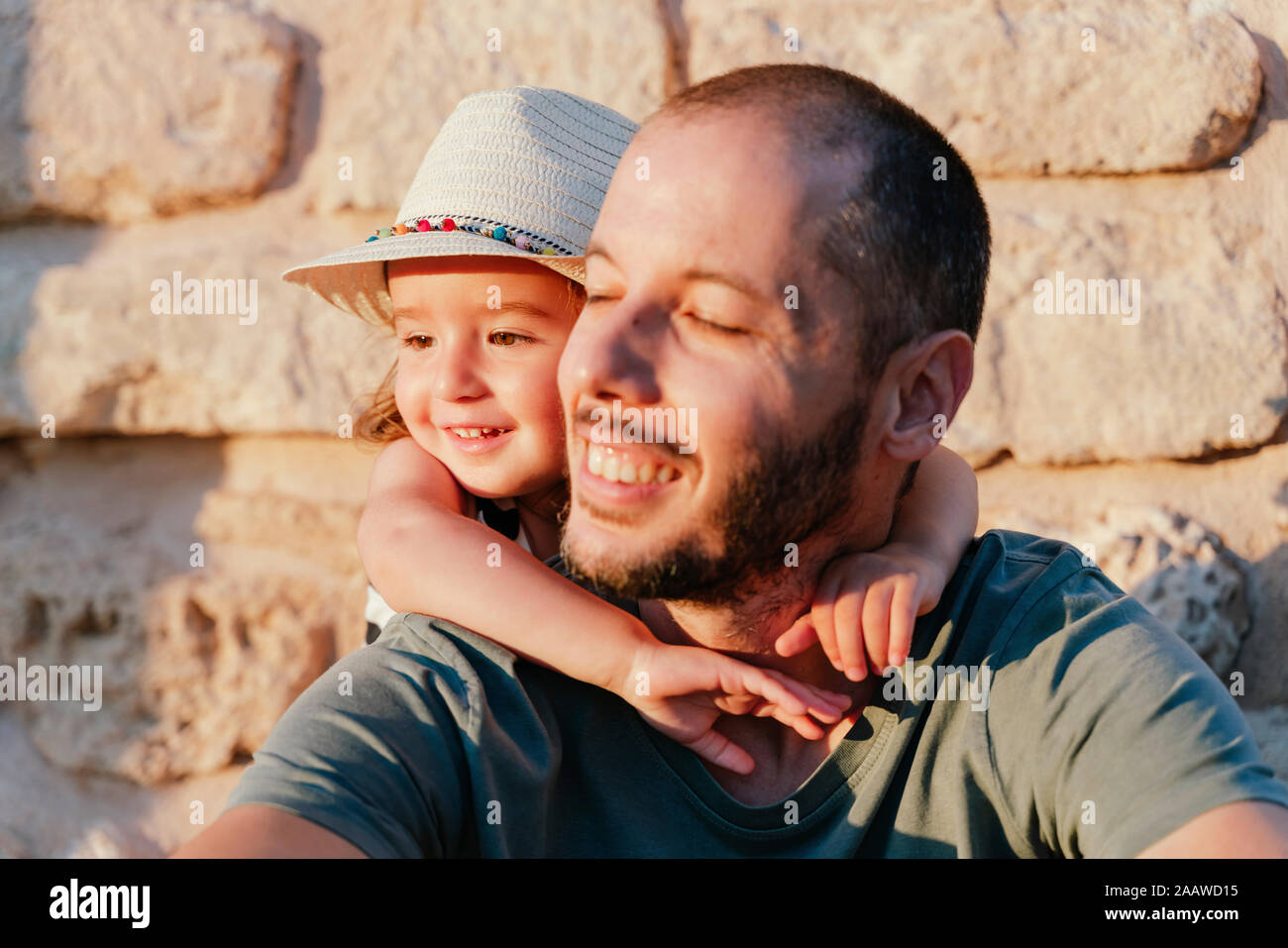 Portrait of smiling little girl hugging her happy father Stock Photo