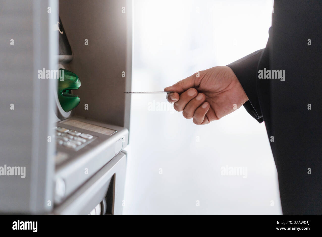 Close-up of businessman withdrawing money at an ATM Stock Photo