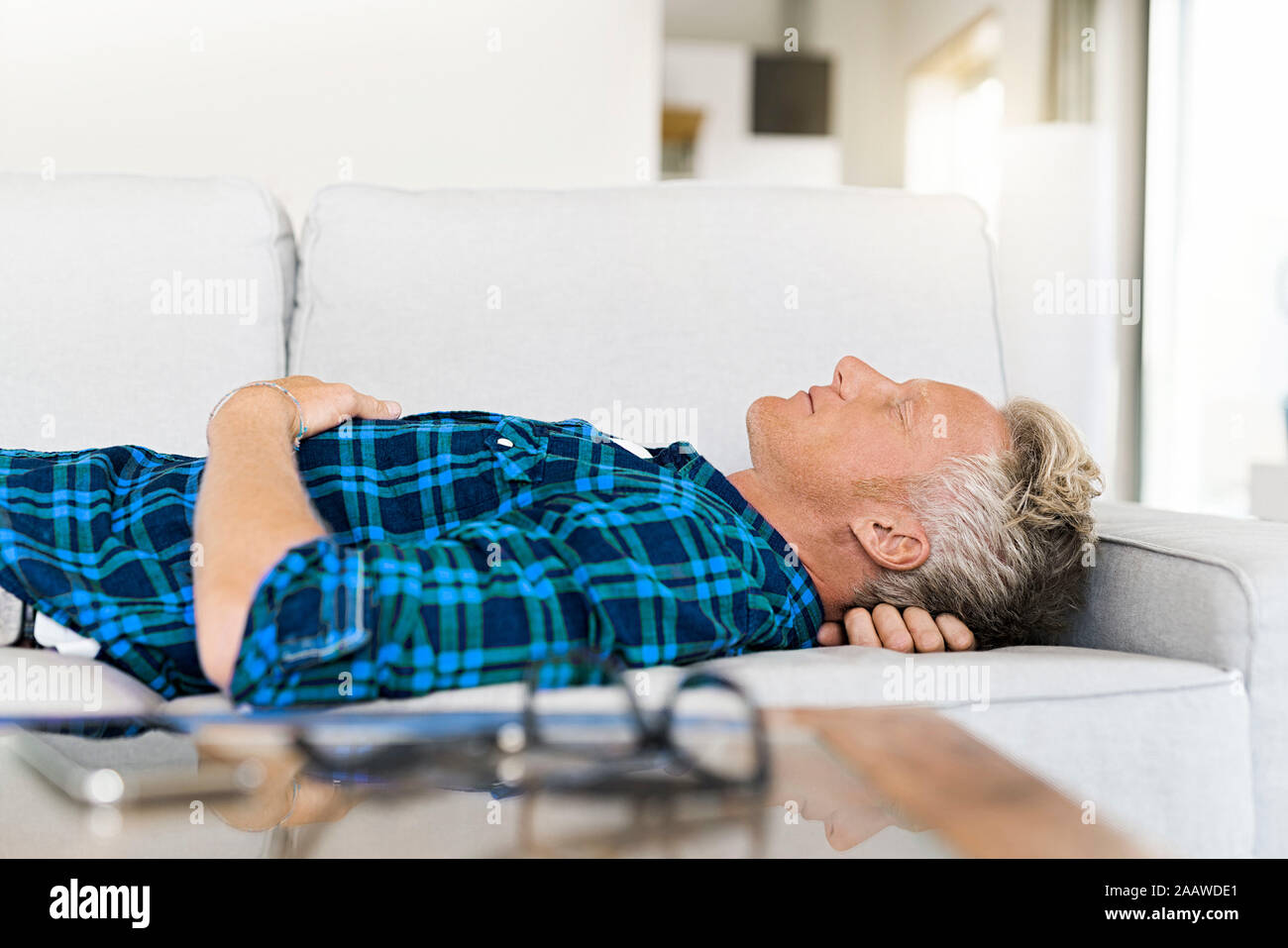 Casual man lying on couch relaxing Stock Photo