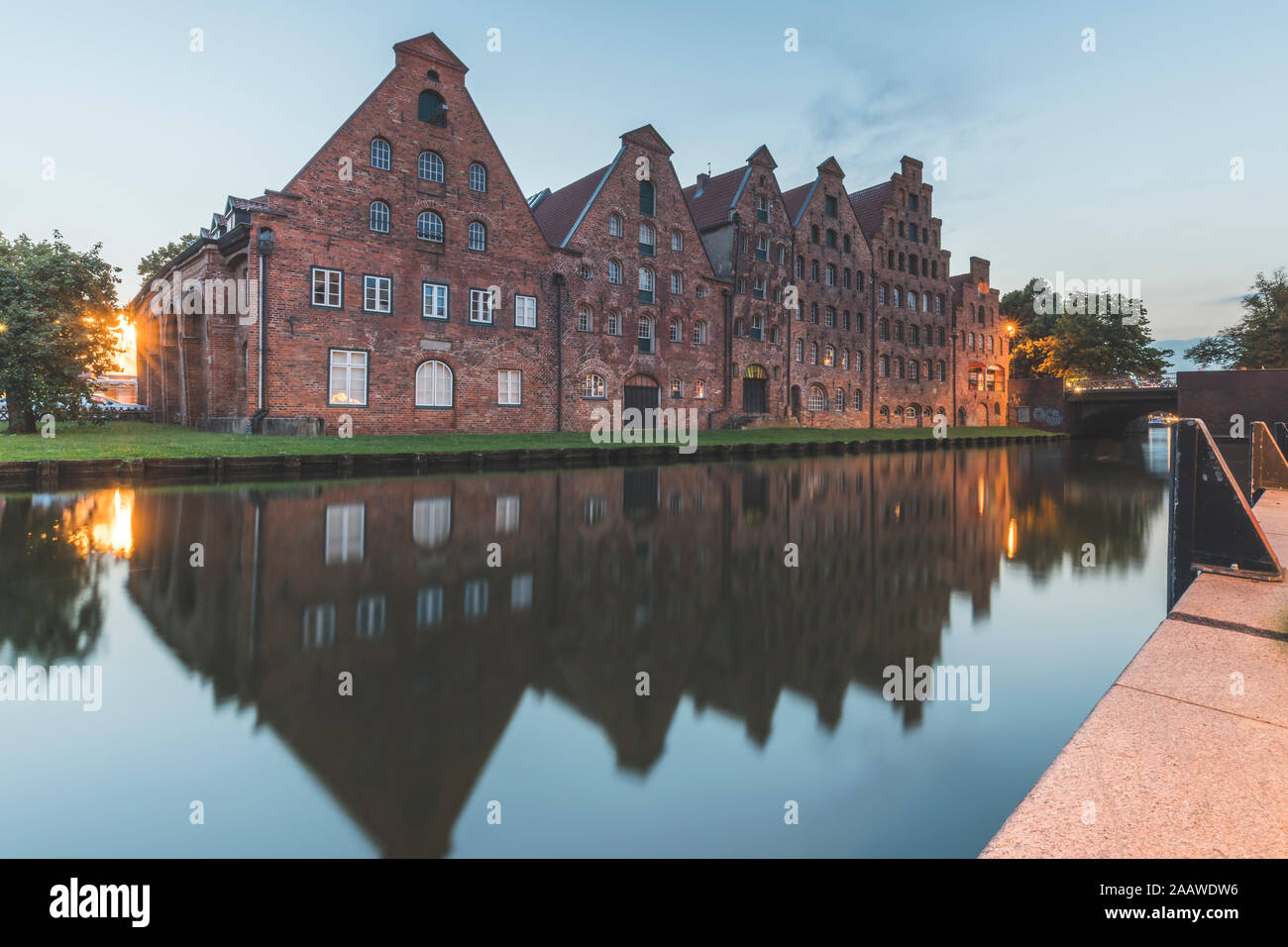 Salzspeicher reflecting on Trave River against sky at dusk, Lübeck, Germany Stock Photo