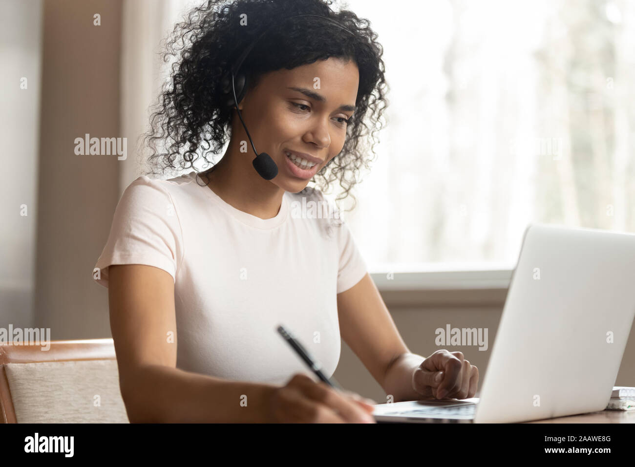 African American woman in headphones watch webinar on laptop Stock Photo