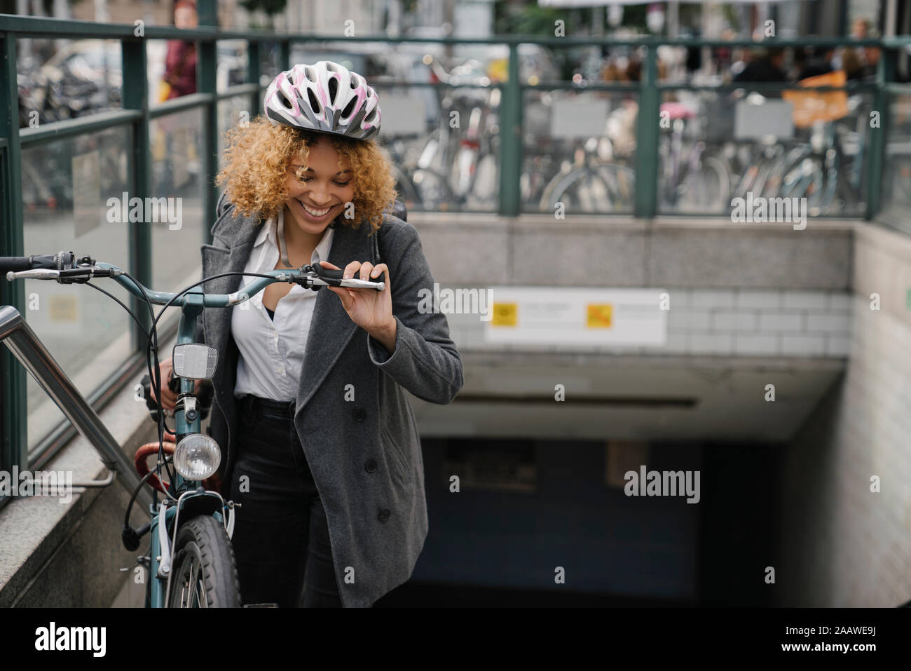 Happy woman with bicycle leaving subway station, Berlin, Germany Stock Photo