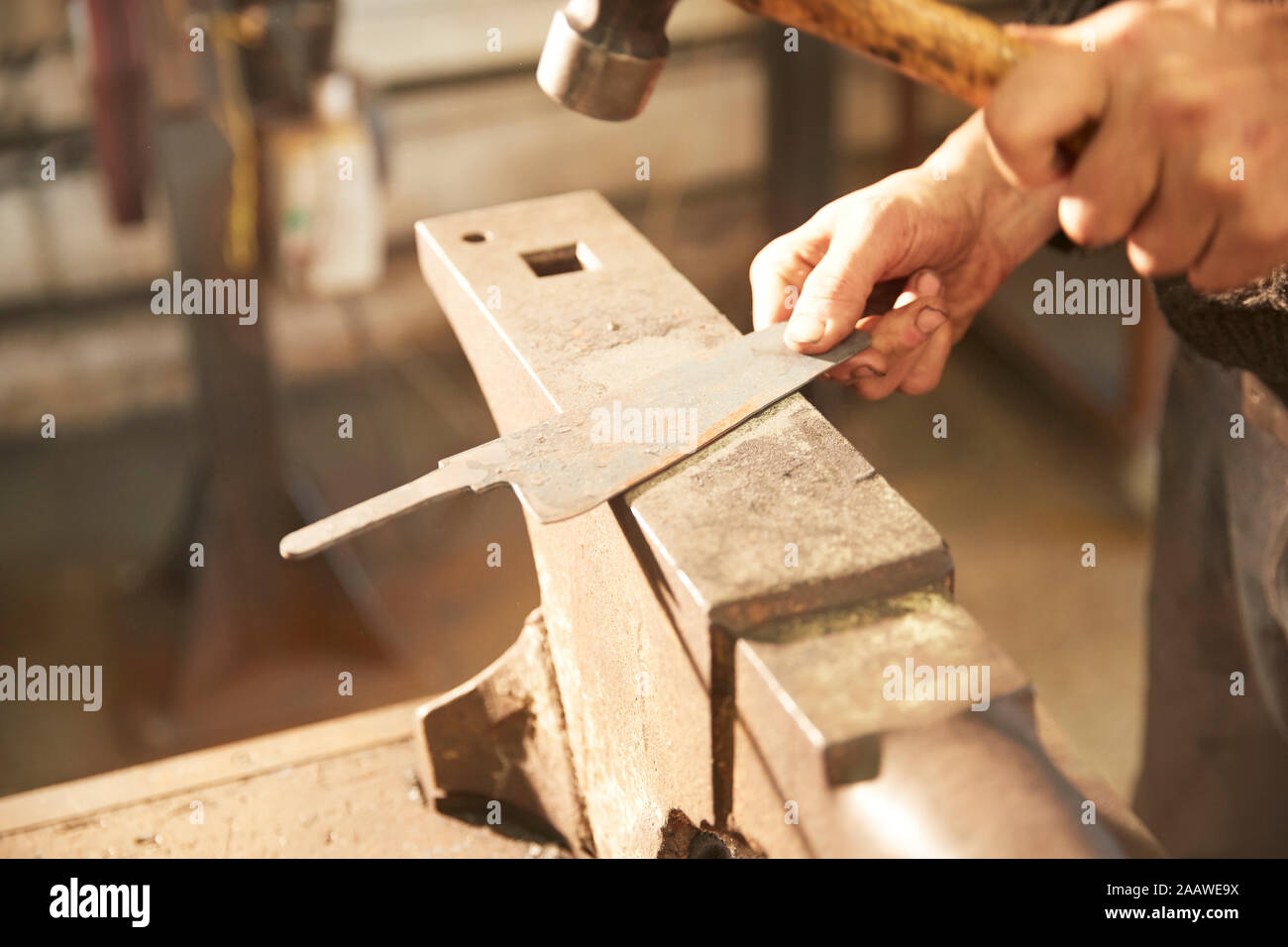 Man finishing blade on an anvil Stock Photo