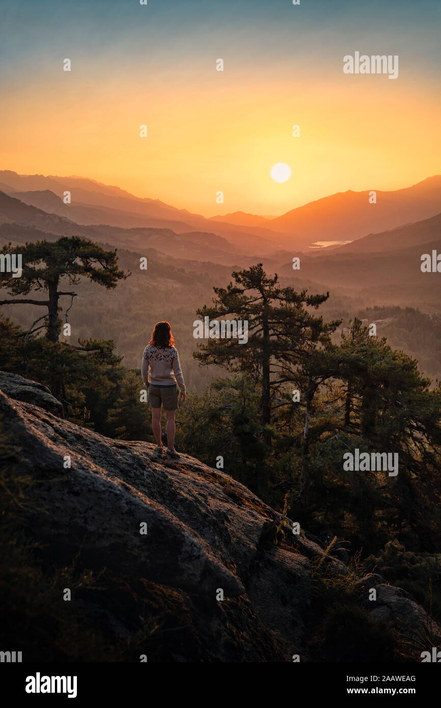 Female hiker standing on viewpoint, Albertacce, Lac de Calacuccia at sunrise, Haute-Corse, Corsica, France Stock Photo