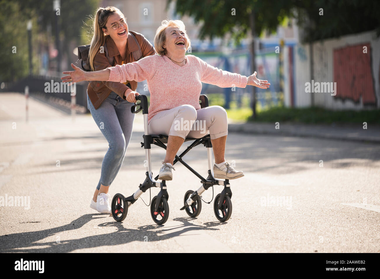 Granddaughter and her grandmother having fun with wheeled walker Stock Photo