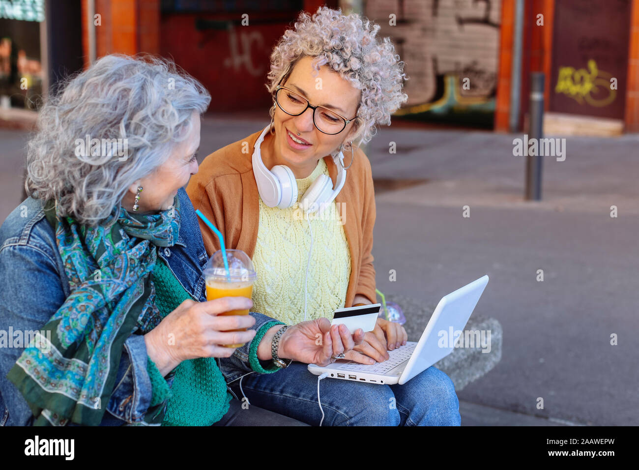 Senior mother with her adult daughter shopping online together in the city Stock Photo